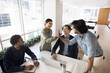 © fizkes - Excited young female share high five with mature male colleague
