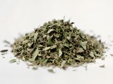 A soft, organic photograph of a loose, textured mound of dried green herbs