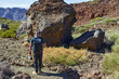 © Xalanx - Hiker with backpack on a trail towards Pico Viejo among giant lava bombs