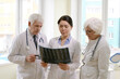 © pressmaster - Group of experienced male and female radiologists looking at X-ray of patient after MRI procedure and discussing his conditions