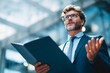 © grey - Businessman holding an open folder while confidently explaining a concept during meeting.