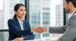 © JARVIS X - Professional Business Handshake Smiling Asian Woman and Man in Suits, Office Window Background, Agreement, Cooperation.