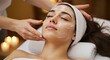 © ms25designs - Woman receiving facial treatment with cream and candles