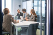 © ty - Business people in the office behind a glass partition in casual clothes, with blurred bokeh background.