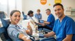 © SerPak - A cheerful woman gives a thumbs up while donating blood in a bright clinic. Medical staff assist patients in a clean, professional environment.