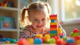 Young girl with pigtails builds tower from colorful blocks in sunlit room. Happy child plays with construction toys, develops creativity, fine motor skills, concentration, learning, indoors.