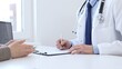 © rogerphoto - Doctor man taking notes while listening to a female patient explaining her symptoms during a medical consultation in the clinic office. Medicine and health care concept