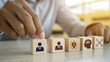 © Ham - Hand pointing to leader icon on wooden blocks symbolizing business hierarchy innovation intelligence and networking on office table