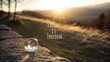 © nashwa - Beautiful sunrise landscape with a crystal ball reflecting nature and an inspiring quote about focus and freedom in the foreground