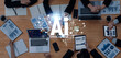 © InfiniteFlow - A top view of a business meeting discussing artificial intelligence, with laptops, tablets, and analytical charts spread on a wooden table, showcasing teamwork and innovation. Trope