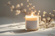 © Purti - A lit scented candle in a glass jar with a blank label is placed beside delicate white baby's breath flowers.