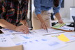 © SOMKID - Business person hands working with business financial graph data and marketing plan at desk in office, Business people meeting explaining and business concept.