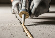 © Mahmuda - Closeup of a worker applying sealant with a caulking gun to seal a crack in a concrete floor, showcasing home improvement and repair work with precision and skill