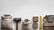 © Kmikhidov - Minimalistic flatlay of construction materials including cement bags, bricks, mortar tools, and measuring tape arranged neatly on a white background, place for text, copy space