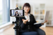 © Sofiia Shunkina - Caucasian woman in business attire recording herself on smartphone discussing business topics in office environment. Concept of video blogging, online content creation.
