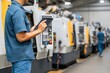 © Leo Rohmann - Industrial technician analyzing machinery performance data using digital tablet in a modern manufacturing environment emphasizing automation advancements and operational efficiency