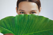 © Buyanskyy Production - Green-Eyed Woman Behind Dewy Leaf In Natural Skincare Eco Beauty Concept