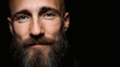 © HISTOCK - Bald man with beard and blue eyes on black background looking at camera