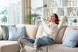 © PheelingsMedia - Happy woman in winter relaxing sitting at home