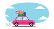 © Jasper - Pink car with luggage and a hat on the roof drives on a road under a blue sky with clouds.