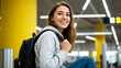 © O - Woman student in a hoodie with a backpack, happy and smiling, ready to travel or commute. Education, journey, and transportation concept.