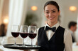 © tynza - Elegant waitress carrying a tray with wine glasses in a fine dining restaurant
