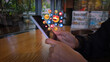 © kingkai - Smartphone with Floating Social Media Reactions in Cafe Setting