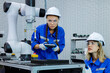 © gumpapa - female automation machine engineer student study and inspection control robot arm machine in university or factory workshop. ai robot technology new innovation trend of manufacturing in industry 5.0