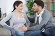© auremar - pregnant woman suffering belly ache and husband comforting