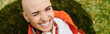 © Bliss - Bald woman enjoying the outdoors in an orange denim jacket while smiling brightly