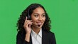 © David Zarzosa - Gently female call center operator talking with headset on green screen background for customer support and communication service.