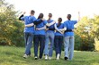 © New Africa - Group of volunteers together in park, back view
