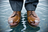Business man's feet in dress shoes standing in clear water, dealing with challenge
