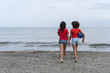 © Hector Pertuz - Girls walking on beach holding hands enjoying friendship