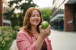 © Halfpoint - Plus size woman holding green apple.