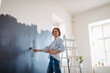 © Halfpoint - Beautiful woman painting walls of her new apartment by herself.