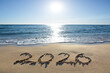 © Swetlana Wall - New Year 2026, lettering on the sunny beach sand.