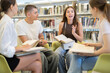 © JackF - Group of students reading and discussing books while sitting on chair in library