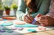 © starush - Woman assembling colorful foam hearts on table for craft project
