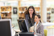 © JackF - Female student helps a friend to deal with the computer in the library. Students preparing for exams
