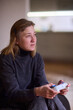 © Евгений Вершинин - Casual female gamer with cerebral palsy, Relaxed woman with gaming controller, Young woman plays video game comfortably at home, Female gamer intently engaging with console in cozy living space