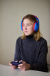 © Евгений Вершинин - Casual female gamer with cerebral palsy, Relaxed woman with gaming controller, Young woman plays video game comfortably at home, Female gamer intently engaging with console in cozy living space