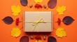 © ANTONW_ - Gift box tied with string surrounded by autumn leaves and berries