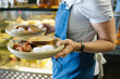 © Austockphoto - Female server serving two breakfast plates with toast, eggs, and bacon