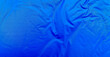 © Ind studio - Smooth blue waterproof fabric with light wrinkles and soft reflections, ideal for background, design mockups, or outdoor gear material texture close-up.