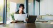 © peopleimages.com - Business, woman and document with laptop at house for real estate, property report and contract. Mature freelancer, pc and paperwork for sales agreement, listing information and negotiation statement