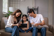 © Apichat - Asian family using digital tablet for learning at home