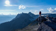 © edb3_16 - Hiker Standing On A Rocky Peak Over Looking Snowy Mountain Range At Dusk Adventure