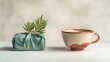 © Line - Green wrapped gift with pine sprig and ceramic cup on soft surface