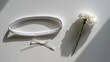 © Line - White headband and decorative flower on clean surface